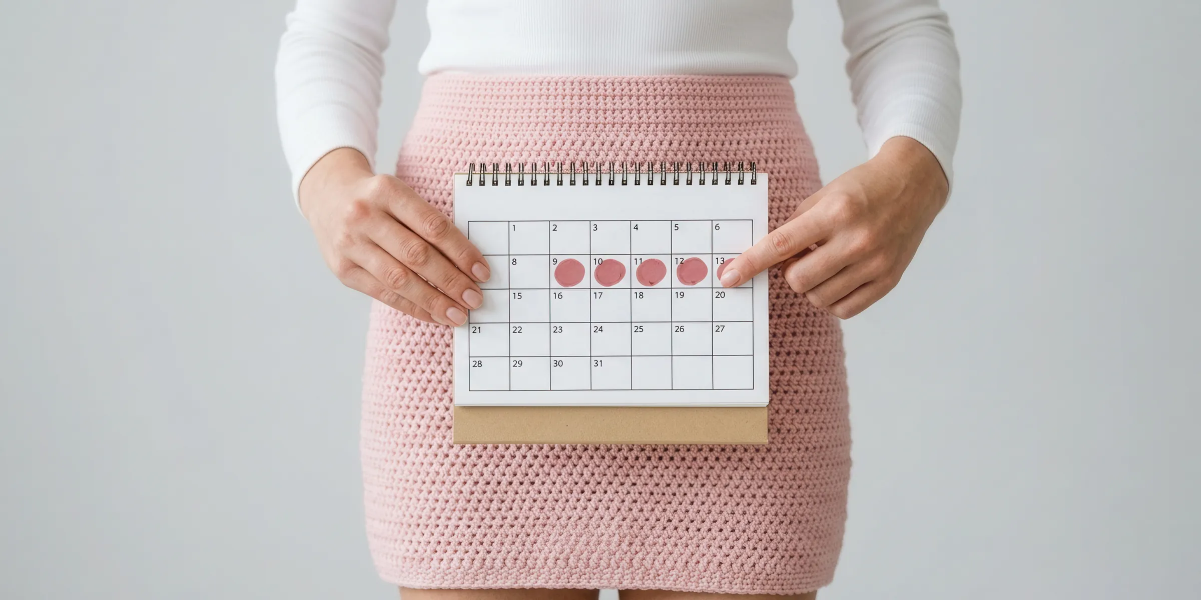 Controle de ovulação: mulher segura um calendário com os dias do período fértil marcados